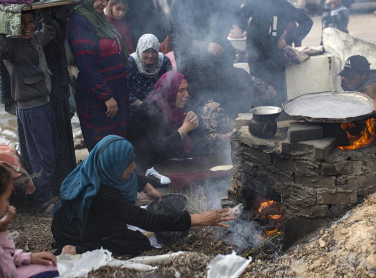 Familias palestinas desplazadas hacen pan en un horno de leña en un campo de refugiados en Rafah, en la Franja de Gaza. EFE/ Haitham Imad