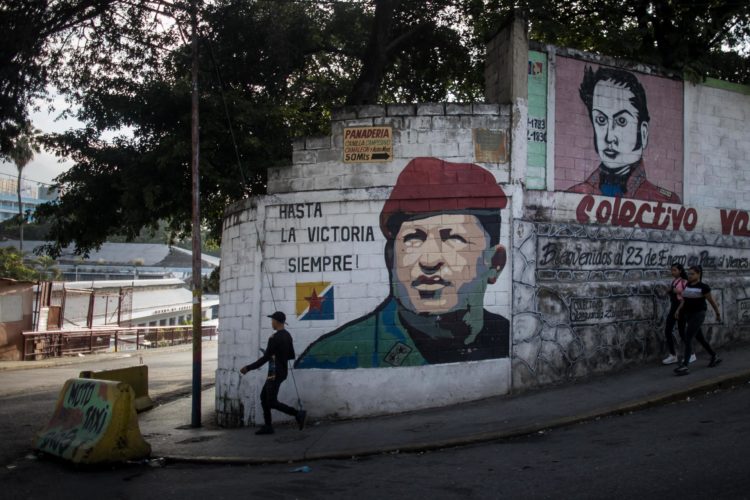Un hombre camina frente a un mural dedicado al fallecido presidente venezolano Hugo Chávez, el 1 de diciembre de 2023, en Caracas (Venezuela). EFE/Miguel Gutiérrez