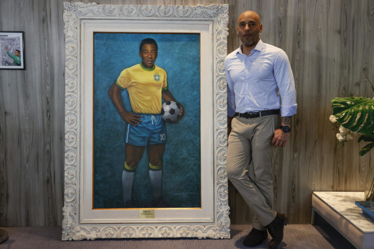 Edinho, hijo de Pelé, posa junto a un retrato de su padre durante una entrevista con EFE, en el Museo Pelé, en la ciudad de Santos (Brasil). EFE/ Sebastiao Moreira