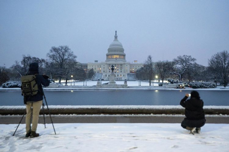 Fotógrafos enmarcan el Capitolio de Estados Unidos tras la primera nevada del año en Washington, DC, Estados Unidos. EFE/EPA/SHAWN THEW