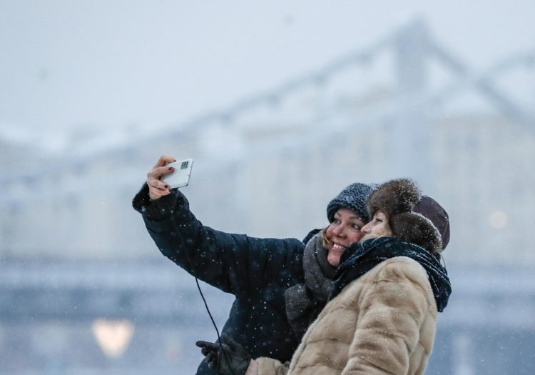Dos mujeres se hacen una foto en Moscú donde hos se espera que las temperaturas bajes a menos 24 grados centígrados. EFE/EPA/Yuri kochetkov