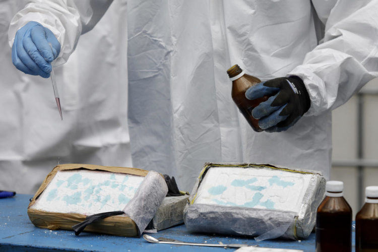Un operario rocía reactivos químicos sobre dos bloques de cocaína para corroborar que se trata de droga, en una fotografía de archivo. EFE/Santiago Fernández