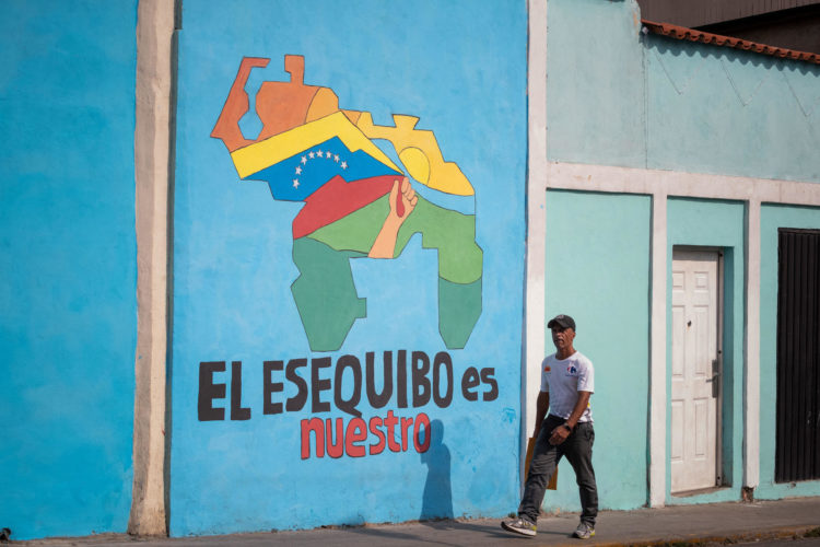 Transeúntes caminan frente a un mural con el mapa de Venezuela que dice "El Esequibo es nuestro", en Caracas (Venezuela), en una fotografía de archivo. EFE/ Rayner Peña R.