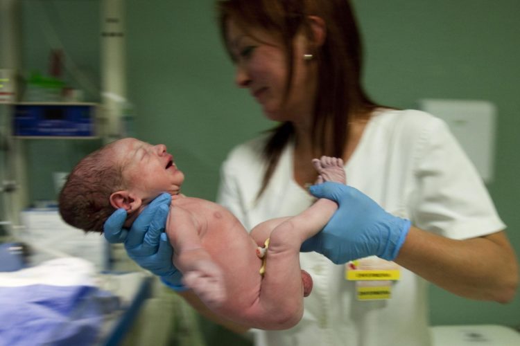 En la imagen de archivo, una enfermera sostiene un bebé recién nacido. EFE/Paulo Cunha