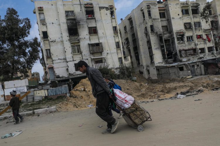 Jan Yunis. Palestinos pasan por edificios destruidos tras una operación militar israelí en Jan Yunis, en el sur de la Franja de Gaza, el 6 de marzo de 2024. . EFE/EPA/MOHAMMED SABLE