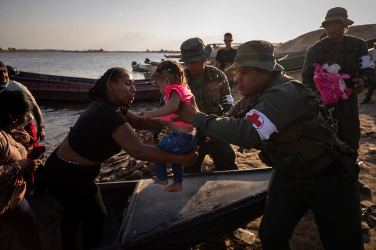 Un militar carga a una niña que llegó junto a su madre provenientes de la mina derrumbada Bulla Loca, en el puerto de La Paragua, en La Paragua, estado Bolívar (Venezuela). EFE/Rayner Pena R.