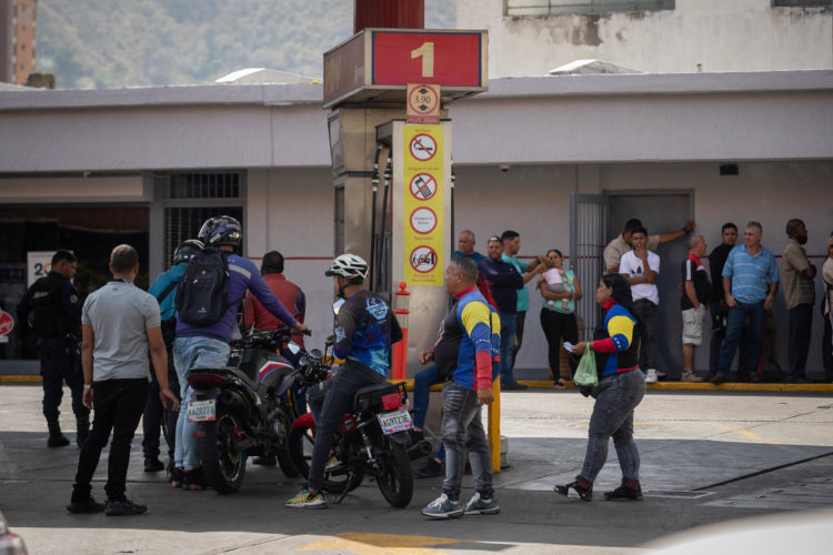 Varias personas hacen fila para abastecerse de combustible este lunes, en Caracas (Venezuela). EFE/Rayner Peña R.