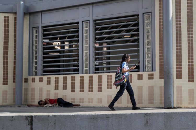 Una joven vestida con uniforme escolar camina en una calle de una zona popular, este miércoles en Caracas (Venezuela). EFE/ Miguel Gutiérrez