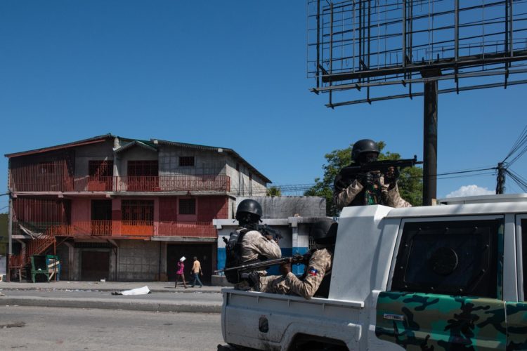 Policías patrullan una calle cercana a la comisaría de Carrefour Aéroport, que fue incendiada por miembros de pandillas, en Puerto Príncipe (Haití). EFE/Johnson Sabin