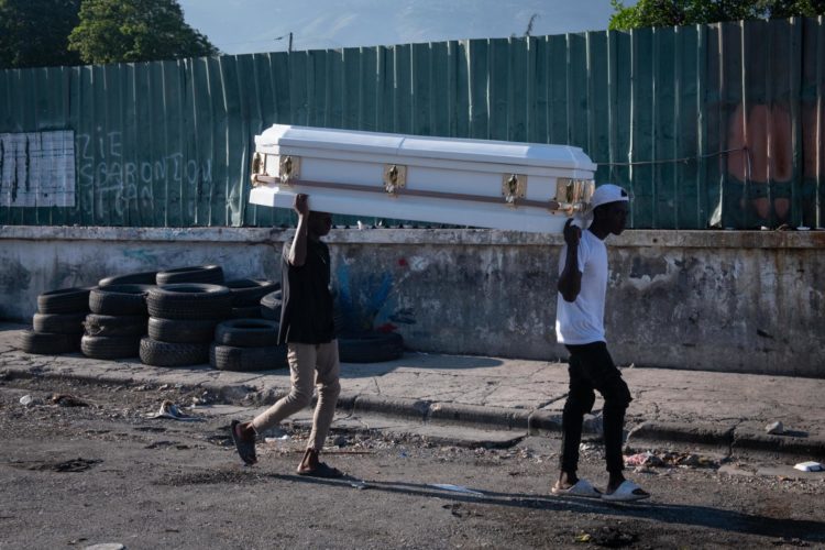 Dos hombres cargan un ataúd por una calle este sábado en Puerto Príncipe (Haití). EFE/ Johnson Sabin
