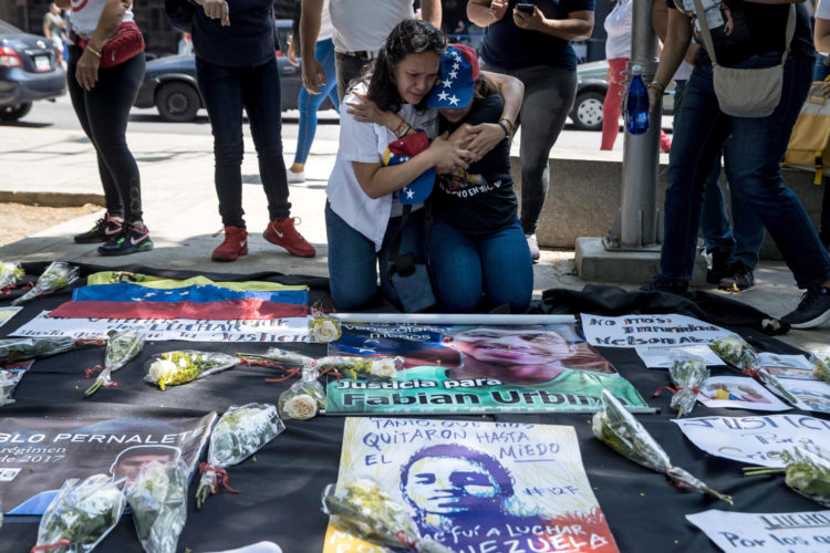 Foto de archivo en donde un grupo de personas participan en una manifestación frente a la sede del Ministerio Publico en Caracas por los asesinados en protestas antigubernamentales en 2017. EFE/ Miguel Gutierrez