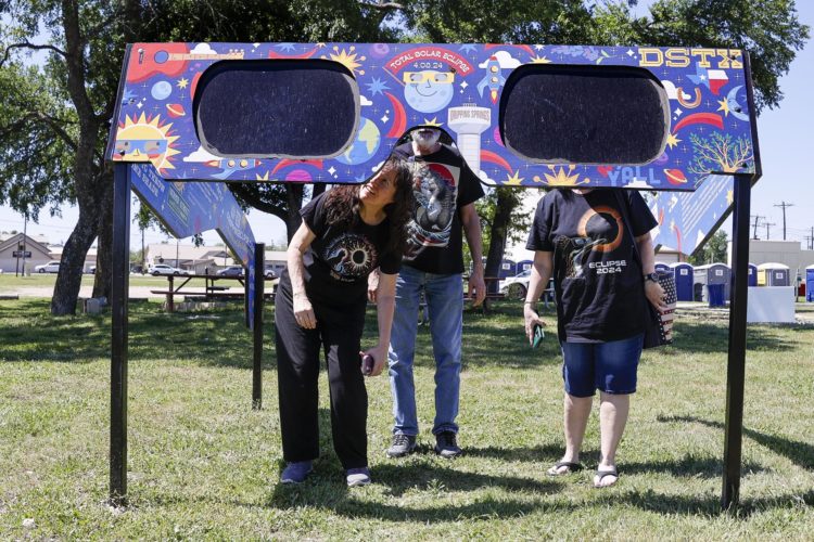 Una familia mira a través de un par de gafas gigantes especiales para el eclipse solar en el Veterans Memorial Park en Dripping Springs, Texas (EE.UU). EFE/Adam Davis