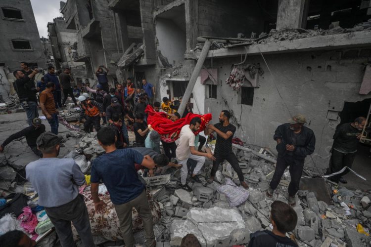 Palestinos recuperan los restos de una persona entre los escombros de una casa destruida tras un ataque aéreo israelí en el campo de refugiados de Al Nusairat, en el sur de la Franja de Gaza, el 27 de abril de 2024.EFE/EPA/MOHAMMED SABLE
