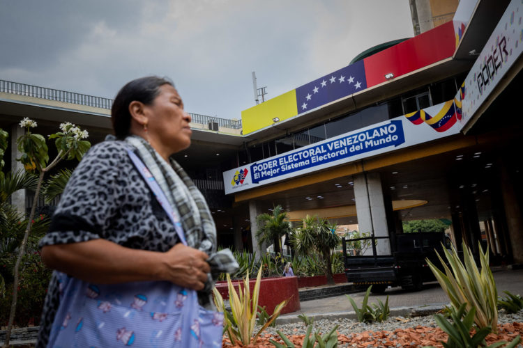 Una persona camina frente a la sede del Consejo Nacional Electoral (CNE), el 17 de abril de 2024, en Caracas (Venezuela). EFE/ Rayner Peña R.
