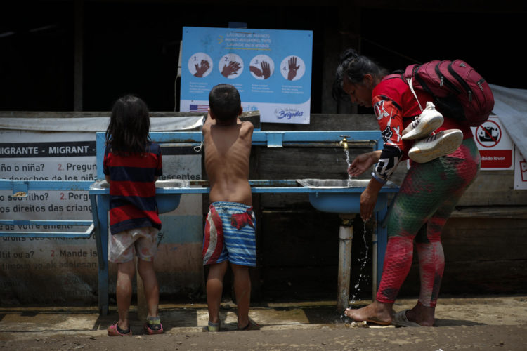 Fotografía de archivo fechada el 3 de mayo de 2024 que muestra a una mujer y dos niños migrantes tras cruzar la selva del Darién en Lajas Blancas (Panamá). EFE/ Bienvenido Velasco