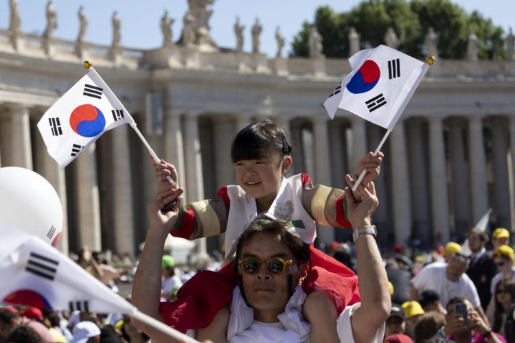 Una niña con banderas surcoreanas espera en la plaza de San Pedro la llegada del papa antes de la misa en el Día Mundial del Niño, el 26 de mayo de 2024. EFE/EPA/MASSIMO PERCOSSI