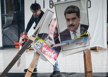 Candidato Daniel Ceballos corta con una motosierra afiches de Maduro y de González Urrutia
