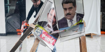 Candidato Daniel Ceballos corta con una motosierra afiches de Maduro y de González Urrutia