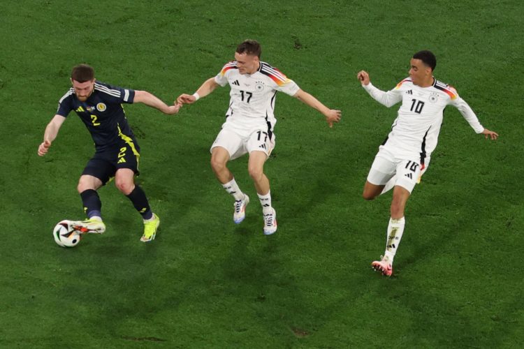 (i-d) El jugador escocés Anthony Ralston en acción contra los alemanes Florian Wirtz y Jamal Musiala de Alemania durante el partido de la Eurocopa 2024 entre Alemania y Escocia en Munich, Alemania. EFE/EPA/MOHAMED MESSARA