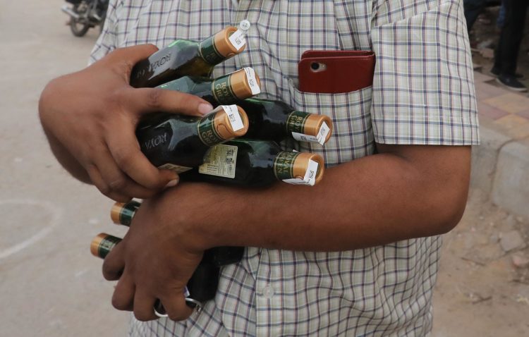 Imagen de archivo de un ciudadano indio con varias botellas de alcohol en Nueva Delhi. EFE/EPA/RAJAT GUPTA
