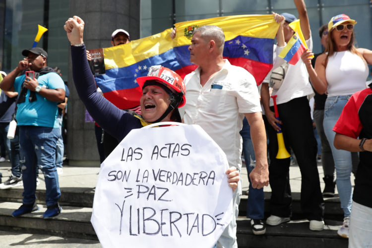 Una mujer sostiene un cartel este martes, durante una protesta contra los resultados dados por el CNE, en Caracas (Venezuela). EFE/ Ronald Peña R.