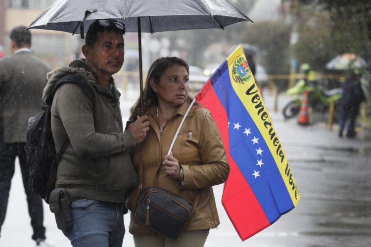 Ciudadanos venezolanos sostienen la bandera de su país durante la jornada de elecciones presidenciales de Venezuela este domingo 28 de julio de 2024 en Bogotá (Colombia). EFE/ Carlos Ortega