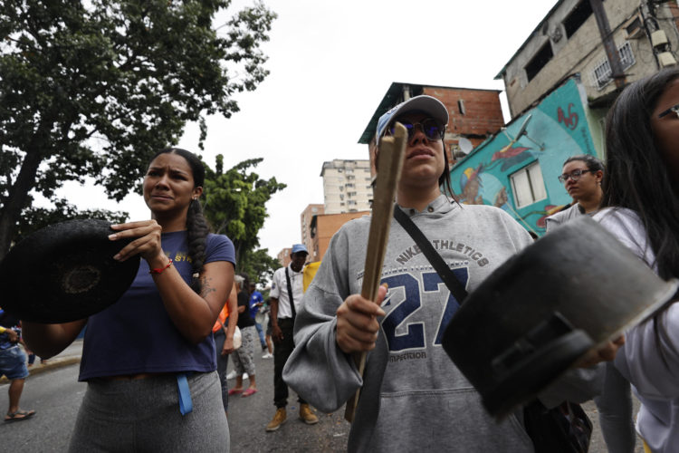 ersonas golpean cacerolas en una manifestación luego de los resultados de las elecciones presidenciales el lunes en Caracas (Venezuela). EFE/ Henry Chirinos