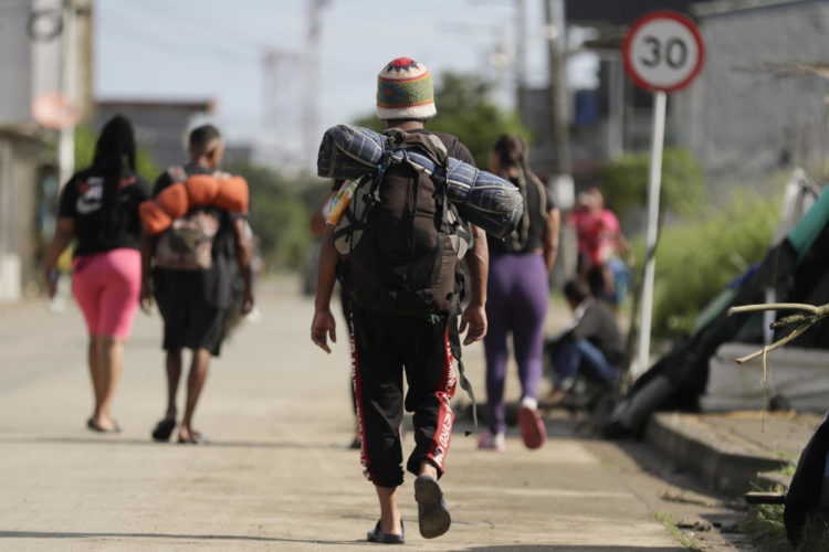 Migrantes caminan por una calle en la subregión de Urabá, en el municipio de Turbo (Colombia). EFE/ Carlos Ortega