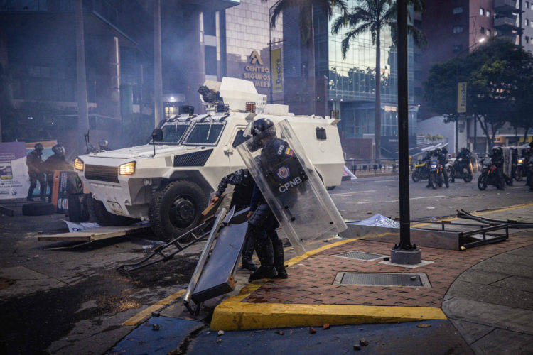 Integrantes de la Guardia Nacional Bolivariana (GNB) se enfrentan a manifestantes por los resultados de las elecciones presidenciales el lunes en Caracas (Venezuela). EFE/ Henry Chirinos