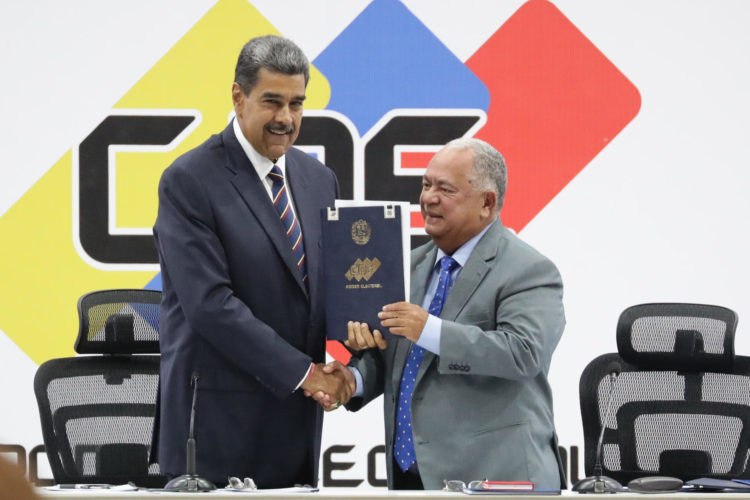 El presidente de Venezuela, Nicolás Maduro (i), y el presidente de Consejo Nacional Electoral (CNE), Elvis Amoroso, sostienen el acta de juramentación del presidente electo este lunes, en Caracas (Venezuela). EFE/ Ronald Peña R.