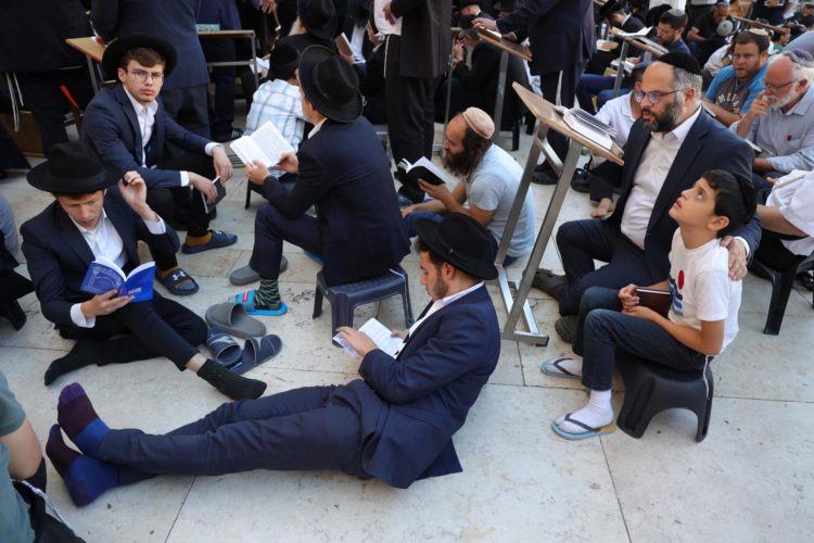 Los judíos ortodoxos rezan mientras leen el libro de Eicha (Libro de las Lamentaciones) para conmemorar Tisha B'av, en el Muro Occidental, en la Ciudad Vieja de Jerusalén, el 13 de agosto de 2024. EFE/EPA/ABIR SULTÁN