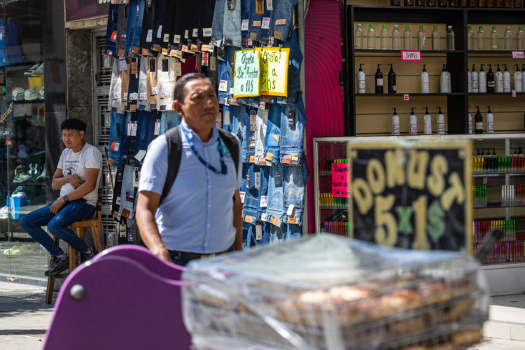 Fotografía de un hombre junto a pantalones para la venta este miércoles, en Caracas (Venezuela).EFE/ Henry Chirinos