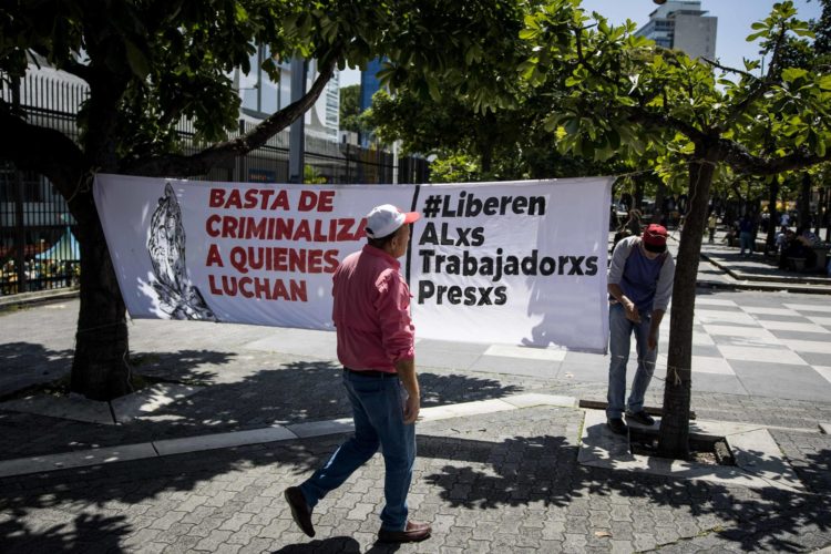 Fotografía del 18 de septiembre de 2024 de una persona instalando una pancarta durante una manifestación para exigir libertad a sus familiares detenidos, en Caracas (Venezuela). EFE/ Miguel Gutiérrez