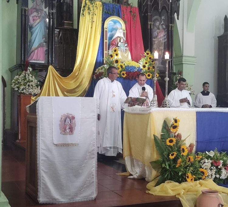 Los sacerdotes oficiantes delante del altar mayor del templo San Juan Bautista.