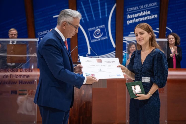 El presidente de la Asamblea Parlamentaria del Consejo de Europa, Theodoros Roussopoulos, entrega a Ana Corina Sosa el premio Vaclav Havel de Derechos Humanos concedido a su madre, la líder opositora venezolana Maria Corina Machado, en la sede de esta institución en la ciudad francesa de Estrasburgo.EFE/EPA/Christophe Petit Tesson