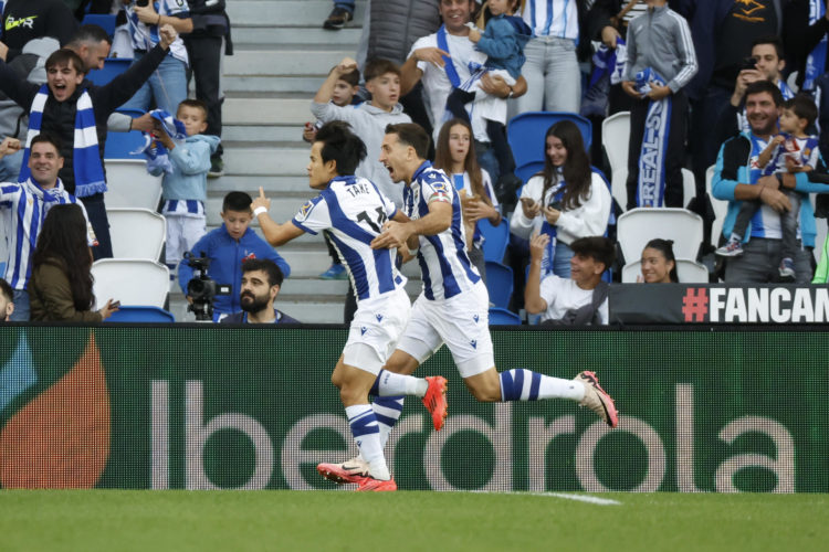 El delantero de la Real Sociedad Take Kubo (i) celebra tras marcar ante el Valencia, durante el partido de LaLiga en Primera División que Real Sociedad y Valencia CF disputaron en el Reale Arena, en San Sebastián. EFE/Javier Etxezarreta