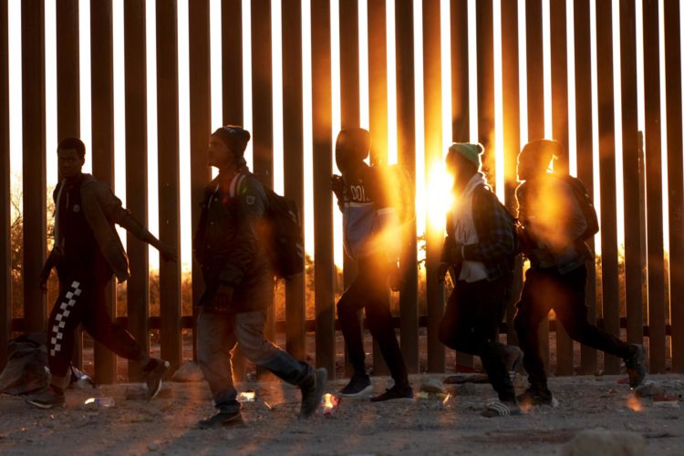 Fotografía de archivo de migrantes que caminan junto al muro en la frontera de EE.UU, y México en Lukeville, Arizona, EE.UU. EFE/ Allison Dinner