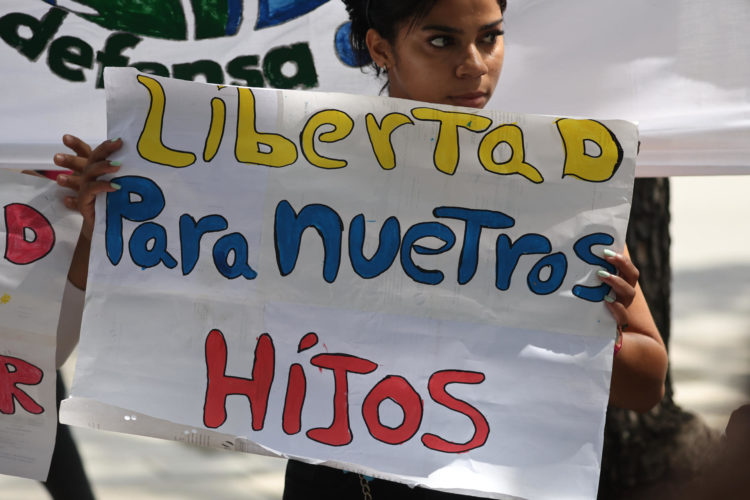 Una mujer sostiene un cartel en una manifestación de familiares de adolescentes detenidos durante las protestas contra los resultados de elecciones presidenciales en Venezuela este jueves, en Caracas (Venezuela). EFE/ Miguel Gutiérrez