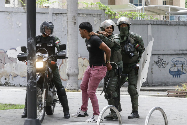 Fotografía de archivo del 30 de julio de 2024 de Integrantes de la Guardia Nacional Bolivariana deteniendo a un manifestante en Caracas (Venezuela). En Venezuela hay 1.808 detenidos considerados como "presos políticos", 15 más que la semana pasada, cuando se computaron 1.793 personas privadas de libertad por "razones políticas", según informó este miércoles la ONG Foro Penal. EFE/ Ronald Peña