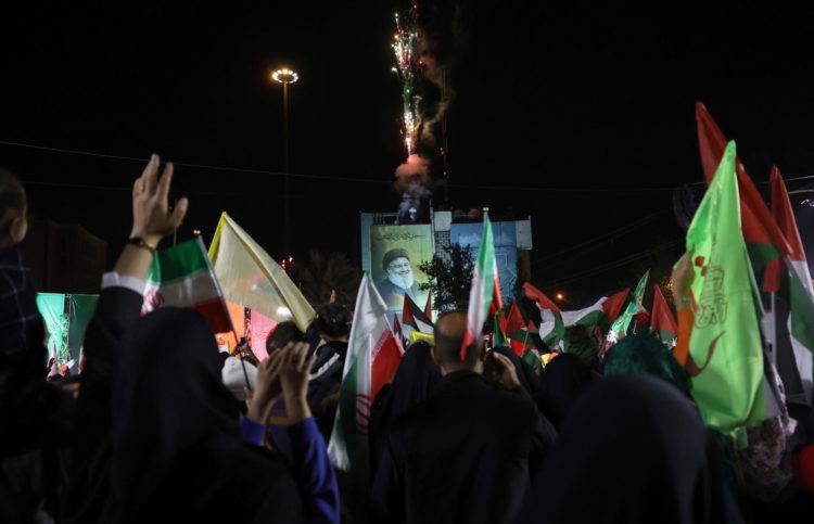 Alrededor de un enorme cartel del difunto líder de Hizbulá, Hasán Nasrala, los iraníes celebran el ataque con misiles contra Israel, en la Plaza Palestina, en Teherán, el 1 de octubre de 2024. EFE/EPA/ABEDIN TAHERKENAREH