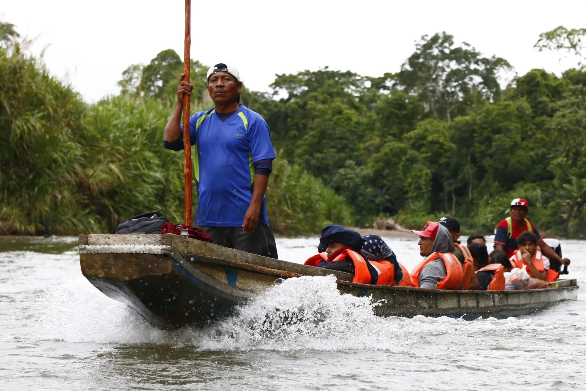 Fotografía del 8 de octubre de 2024 de migrantes transportándose en una lancha por el rio Turquesa desde el pueblo de Bajo Chiquito al centro de recepción migratoria de Lajas Blancas (Panamá). EFE/Moncho Torres.