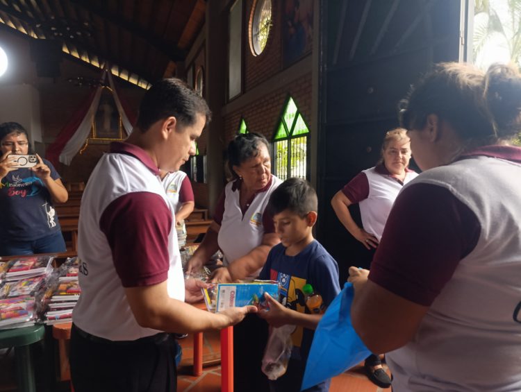 El sacerdote Ronald Gaitán hace entrega de kits a niños de las comunidades eclesiales de base de la parroquia San Juan Bautista. Fotos:  Josir Cegarra