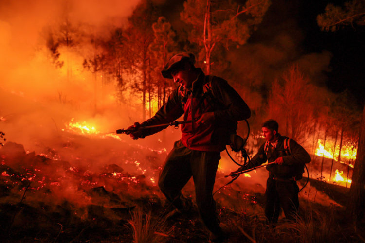 Fotografía de archivo de dos hombres parte de un grupo de bomberos y vecinos autogestionados que combaten un incendio forestal en Intiyaco en las cercanías de Villa Berna, provincia de Córdoba (Argentina). EFE/ STR