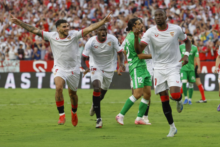 El centrocampista belga del Sevilla Dodi Lukebakio (i) celebra con sus compañeros su gol marcado de penalti durante el partido de la novena jornada de LaLiga que Sevilla FC y Real Betis disputaron en el estadio Ramón Sánchez-Pizjuán, en Sevilla. EFE/Julio Muñoz