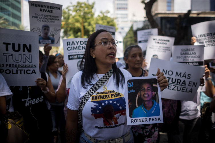 Fotografía del 18 de octubre de 2024 en donde se ve a una mujer sostiene un cartel con la imagen de un detenido durante una manifestación frente a la sede del Ministerio de Servicio Penitenciario, en Caracas (Venezuela). EFE/ Miguel Gutierrez