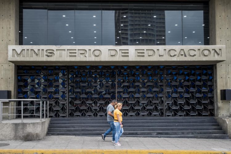 Fotografía de archivo del 21 de abril de 2023 de dos personas frente a las instalaciones del Ministerio de Educación, en Caracas (Venezuela).EFE/ Miguel Gutiérrez