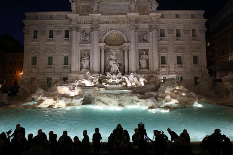 Turistas contemplan la Fontana de Trevi, en Roma, iluminada de noche. EFE/Alessandro Di Meo/Archivo