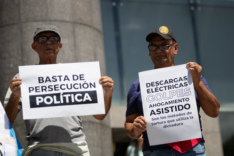 Imagen de archivo de personas que sostienen carteles durante una manifestación frente a la sede de la ONU en Caracas. EFE/ Ronald Peña R.