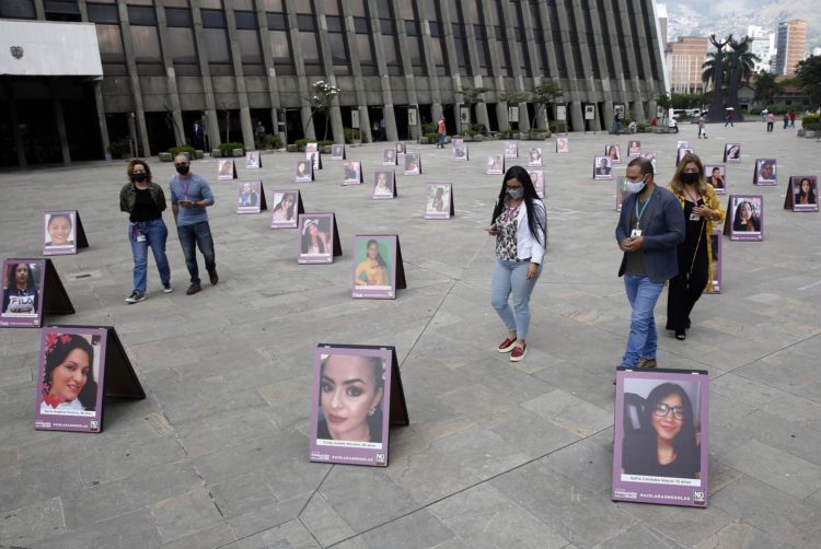 Fotografía de archivo que muestra a varias personas caminando en medio de retratos que forman parte de una exposición fotográfica en homenaje a mujeres víctimas de feminicidio, en Medellín (Colombia). EFE/ Luis Eduardo Noriega A.