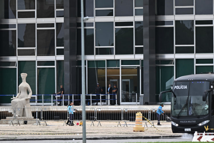 Trabajadores del servicio de limpieza urbana limpian el área cerca a sede de la Corte Suprema en la Plaza de los Tres Poderes este jueves en Brasilia (Brasil). EFE/Andre Borges